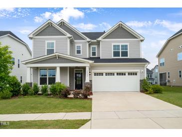 Charming two-story home showcasing a two-car garage, lush landscaping, and inviting curb appeal at 5420 Mill Dam Rd, Wake Forest, NC 27587