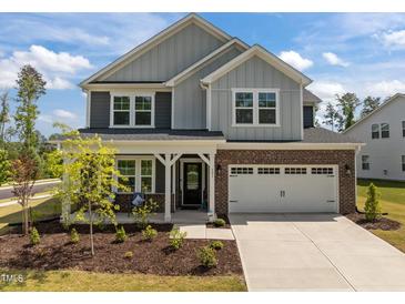 Charming two-story home featuring a brick and siding facade, and a two-car garage at 601 Lauren Ann Dr, Apex, NC 27523