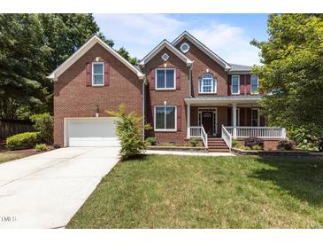 Charming two-story brick home with a well-manicured lawn and inviting front porch at 708 Cheselden Dr, Durham, NC 27713
