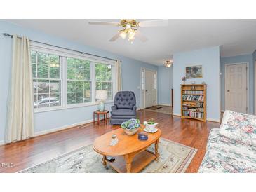 Bright living room with large window, hardwood floors, and floral sofa at 790 Cashmere Ct, Sanford, NC 27332