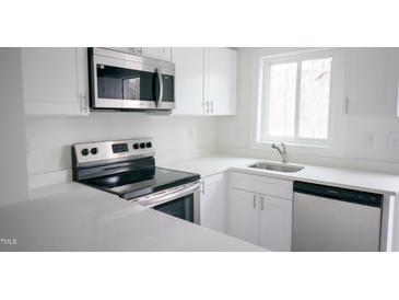 Bright kitchen featuring stainless steel appliances, modern cabinets, and a quartz countertop at 800 Pritchard Avenue Ext # H4, Chapel Hill, NC 27516