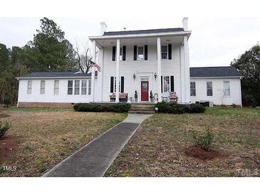 Charming two-story white home featuring a traditional front porch and manicured lawn at 100 Lager Ln, Garner, NC 27529