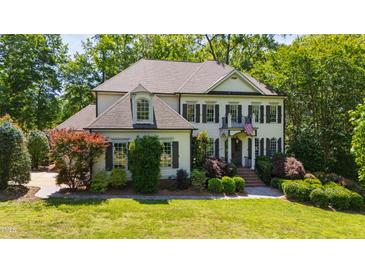 Charming two-story home with lush landscaping, dark shutters, and welcoming front entrance at 1329 Wynncrest Ct, Raleigh, NC 27603