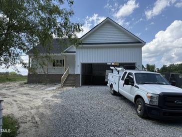New construction home featuring an attached garage, gravel driveway and a truck parked in front at 168 Clayton Rd, Princeton, NC 27569