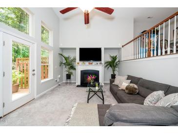 Bright living room boasts a fireplace, vaulted ceilings, and an abundance of natural light at 3034 Winfred Dell Ln, Cary, NC 27511