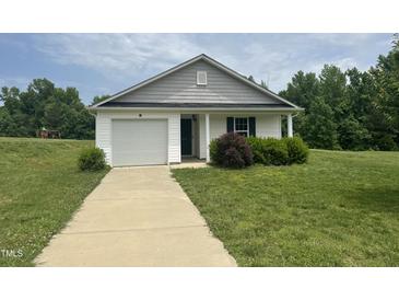 Charming single-story home with attached garage and well-maintained front lawn at 5219 Merlin Dr, Snow Camp, NC 27349