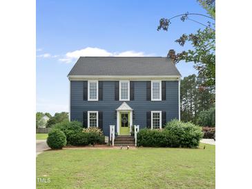 Charming two-story home with a manicured lawn, black shutters, and a bright green front door at 6 W Canterbury Ct, Wendell, NC 27591