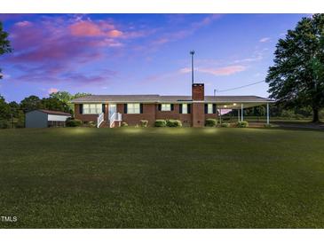 Charming single-story brick home featuring a spacious front lawn and a covered carport at 6080 Us 421 N, Lillington, NC 27546