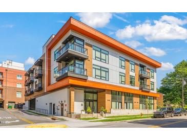 Modern condo building with balconies and a colorful exterior design on a sunny day at 615 Daniels St # 215, Raleigh, NC 27605