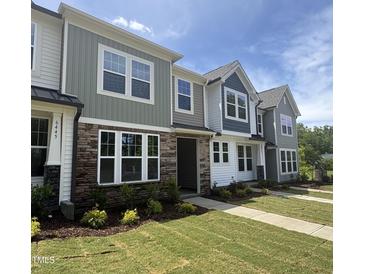 Charming townhomes with stone accents, multiple windows and beautifully landscaped front yards at 6447 Granite Quarry Dr, Raleigh, NC 27610