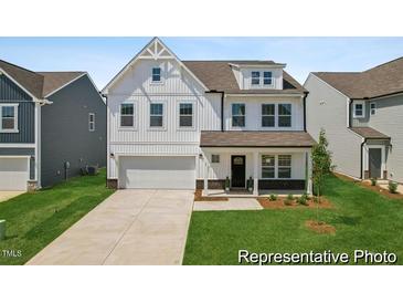 Charming two-story home with white siding, a two-car garage, and a well-manicured lawn at 88 Mable Court # 17, Lillington, NC 27546