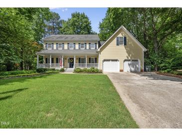 Charming two-story traditional home with a welcoming front porch and well-manicured lawn at 1007 Surry Dale Ct, Apex, NC 27502