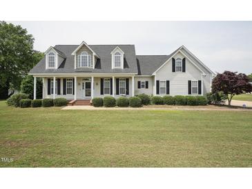 Charming two-story home with a welcoming front porch, manicured lawn, and classic black shutters at 105 Bagley Ln, Dunn, NC 28334