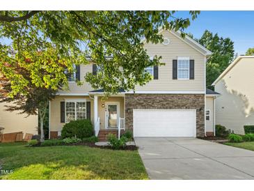 Two-story home with stone accents, a two-car garage, neutral siding, and a well-manicured lawn at 109 Faldo Cv, Raleigh, NC 27603