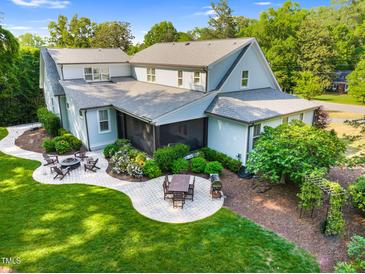 Charming backyard featuring an outdoor dining area and a cozy fire pit, perfect for entertaining at 125 Lord Ashley Rd, Raleigh, NC 27610