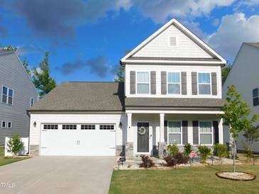 Traditional two-story home featuring a two car garage, manicured lawn and stone accents at 1311 Arena Ln, Fuquay Varina, NC 27526