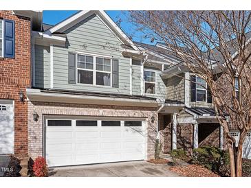 Charming townhome with a two-car garage, brick accents, and light blue siding at 2082 Weston Green Loop Loop, Cary, NC 27513