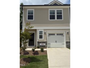 Charming two-story home features a front-entry garage, neutral siding, and a well-maintained lawn and landscaping at 253 Hank Way, Angier, NC 27501