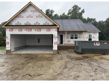 Exterior of a new home under construction with an attached garage and a dumpster for waste removal at 2776 Rains Mill Rd, Princeton, NC 27569