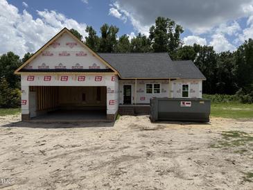 Exterior view of new home construction featuring attached garage and dumpster at 2776 Rains Mill Rd, Princeton, NC 27569