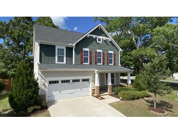 Charming two-story home showcasing a manicured lawn, attached garage, and inviting front porch at 2855 Wilkes Lake Dr, Fuquay Varina, NC 27526