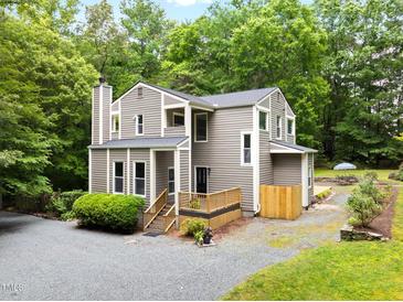 Attractive multi-story home featuring a wood-lined exterior, complemented by lush greenery at 406 Johns Woods Rd, Chapel Hill, NC 27516