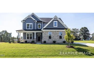 Charming two-story home featuring blue siding, brick accents, and a well-manicured lawn at 422 Grading Stick Ct, Angier, NC 27501