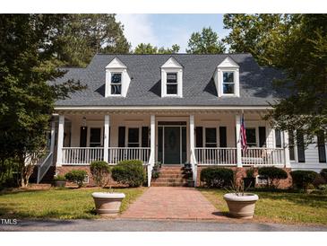 Charming home with a large porch, white columns and black shutters at 9200 Lake Carol Dr, Zebulon, NC 27597