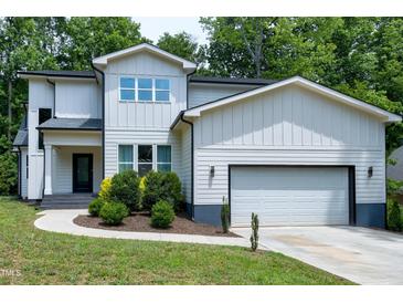 Charming two-story home featuring a two-car garage, complemented by well-manicured landscaping at 1003 E Sterlington Pl, Apex, NC 27502