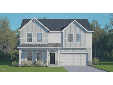 Charming two-story home featuring board and batten siding, a covered front porch, and an attached two-car garage at 128 Gilmer St, Fuquay Varina, NC 27526