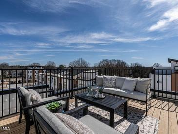 Relaxing outdoor deck featuring comfortable seating, a coffee table, and a beautiful view of the surrounding neighborhood at 1408 Sawyer Rd # 103, Raleigh, NC 27610