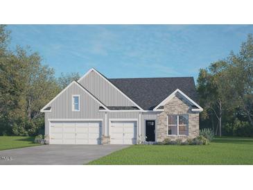 Charming home with a symmetrical elevation, 2-car garage, stone details, and inviting curb appeal at 148 Gilmer St, Fuquay Varina, NC 27526