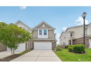 Charming two-story townhouse with a brick facade, white garage door, and well-maintained lawn and landscaping at 1534 Glenwater Dr, Cary, NC 27519