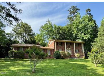 Traditional brick home with well-manicured lawn and mature trees at 1818 Brookrun Rd, Henderson, NC 27536