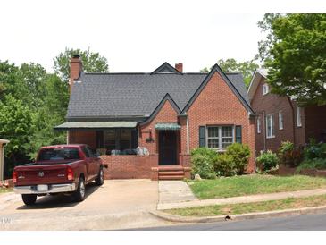 Charming brick home featuring a classic design, complemented by lush greenery and a well-maintained yard at 2210 Hope St, Raleigh, NC 27607
