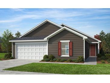 Charming single-story home featuring a classic design with a two-car garage and well-manicured landscaping at 223 Norman Ave, Lillington, NC 27546