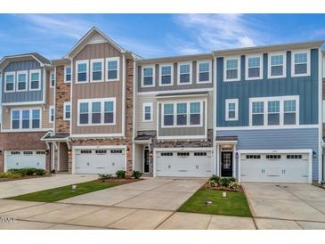 Charming townhouse exteriors boast a mix of stone, siding, and contrasting trim at 2299 Bay Minette Sta # 537, Apex, NC 27502