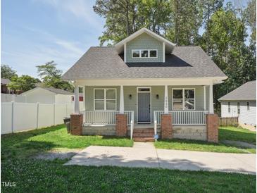 Charming single-Gathering home featuring a welcoming front porch and well-maintained lawn at 2620 Holloway St, Durham, NC 27703