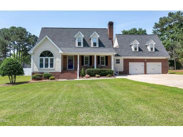 Charming two-story brick home with well-manicured lawn and dormer windows at 2709 Les Paul Ln, Apex, NC 27539