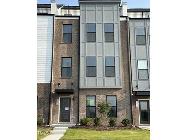 Charming townhome with brick and gray facade, modern windows, and well-maintained landscaping at 2908 Kempthorne Rd # 53, Cary, NC 27519