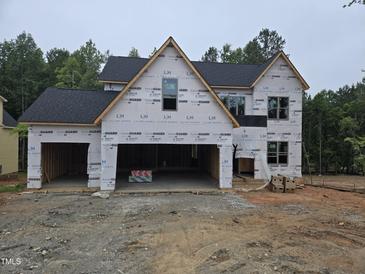 New construction home featuring a two-car garage and partially finished facade in a wooded location at 3905 Cedar Knolls Dr, Youngsville, NC 27596