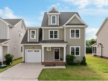 Charming two-story home with a landscaped front yard and a two-car garage and inviting front porch at 418 Wyndham Drive, Chapel Hill, NC 27516