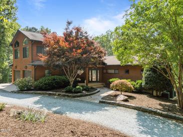 Charming home featuring a well-manicured front yard with mature landscaping, a gravel driveway and a welcoming entrance at 4312 Mystic Ln, Hillsborough, NC 27278