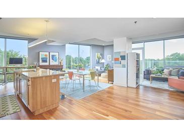 Bright, open-concept living space with hardwood floors and modern furniture, plus island with seating at 601 W Rosemary St # 416, Chapel Hill, NC 27516
