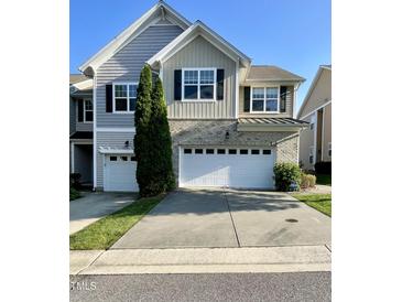 Charming townhome featuring a two-car garage, neutral siding, and manicured lawn at 7241 Terregles Dr, Raleigh, NC 27617