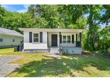 Charming single-story home featuring a welcoming front porch and tidy landscaping at 104 Archdale Dr, Durham, NC 27707