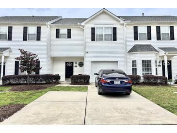 Charming townhome with white siding, black shutters, and a well-maintained front yard and driveway at 104 Fox Trail Ln, Morrisville, NC 27560