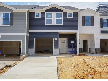 View of new construction townhomes with attached garages and unfinished landscaping at 1052 Winding Spring Drive, Mebane, NC 27302