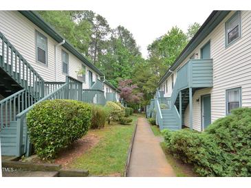 Apartment building exterior featuring painted siding, green trim, and stairs to the second level at 107 Ashley Forest Rd # B, Chapel Hill, NC 27514