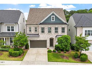 Charming two-story home with light brick, a two-car garage and a well-manicured lawn at 113 Mazarin Ln, Cary, NC 27519
